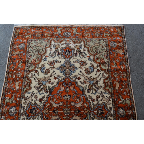 12 - Indo Persian rug with a medallion and hunting design in shades of iron red and cream, 183cms x 122cm... 