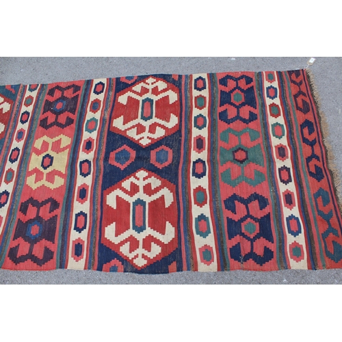 14 - Kelim runner with all-over hooked medallion design in shades of red, blue, cream and yellow, 340cms ... 