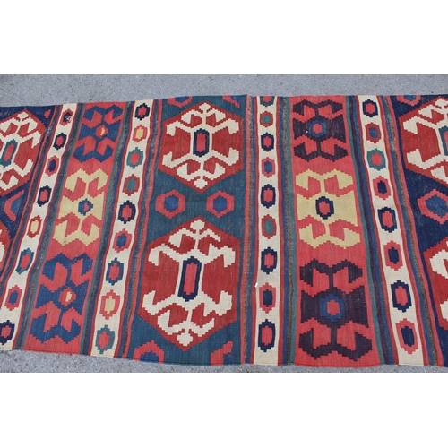 14 - Kelim runner with all-over hooked medallion design in shades of red, blue, cream and yellow, 340cms ... 