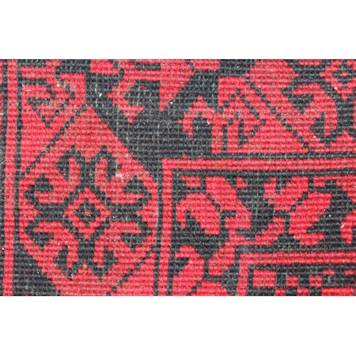 2 - Afghan carpet on wine ground, (some moth damage),  288cm x 198cm