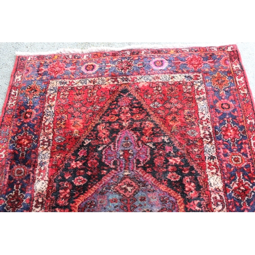 21 - Hamadan rug with a lobed medallion and all-over Herati design in shades of predominantly red and blu... 