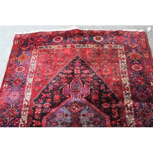 21 - Hamadan rug with a lobed medallion and all-over Herati design in shades of predominantly red and blu... 