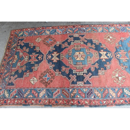 26 - Kurdish rug with a medallion design on a wine ground with borders