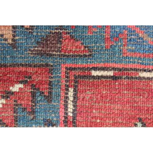 26 - Kurdish rug with a medallion design on a wine ground with borders