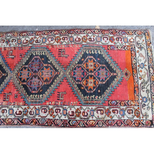 32 - Kurdish runner with a repeating stylised floral medallion design on a pink ground with borders, 280c... 