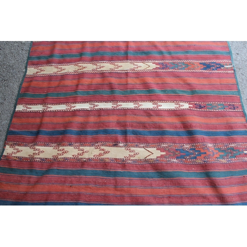 39 - Kelim rug with a polychrome banded design, 270cms x 133cms approximately (repairs and damages)