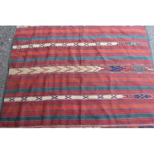 39 - Kelim rug with a polychrome banded design, 270cms x 133cms approximately (repairs and damages)