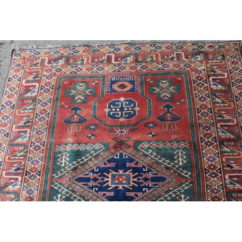 43 - 20th Century Kazak rug with a medallion and all-over stylised design on a red ground with multiple b... 