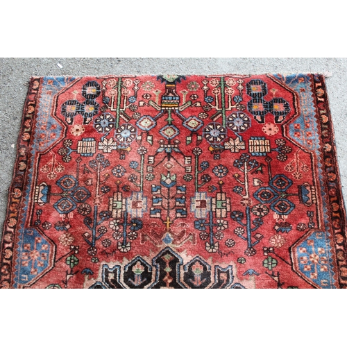 44 - Navahand rug with a medallion and all-over stylised floral design on a red ground (ends cut), 160cms... 