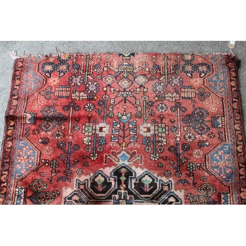 44 - Navahand rug with a medallion and all-over stylised floral design on a red ground (ends cut), 160cms... 