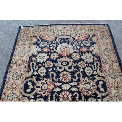 46 - Modern Afghan rug of Ziegler design with a palmette pattern on a dark blue ground, with beige and ro... 