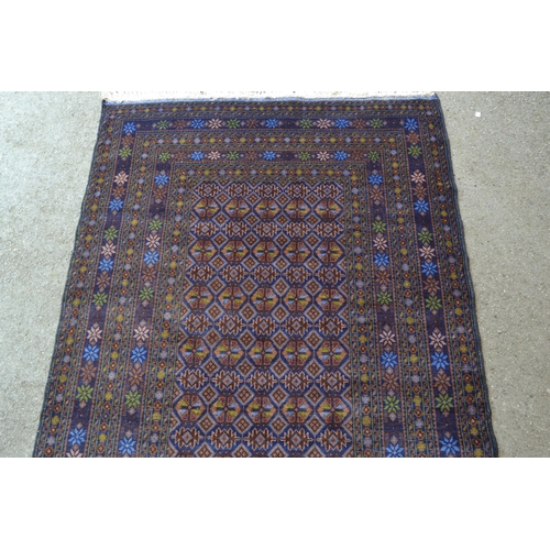 9 - Modern Belouch rug with an all-over stylised flower head design in rectangular centre panel, with mu... 