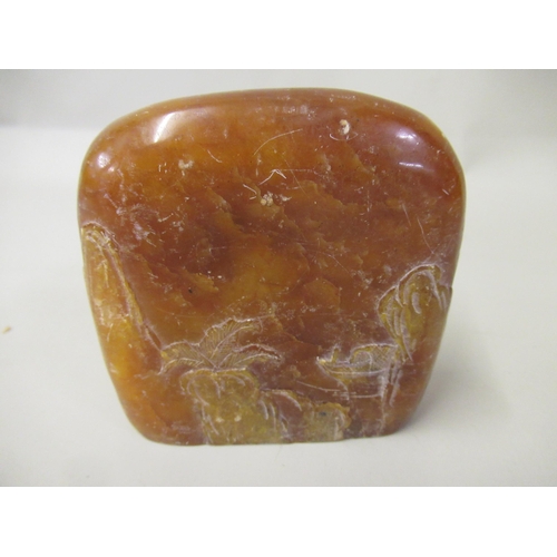 119 - Amber coloured soapstone carving decorated in shallow relief with figures and landscape, double side... 