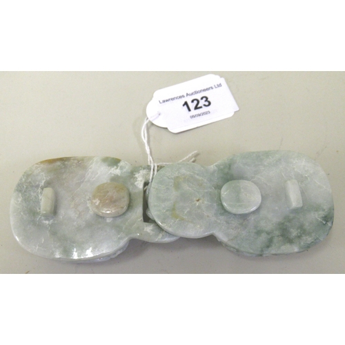 123 - 20th Century carved mottled pale green jade belt buckle in two parts, decorated in deep relief, 12.5... 