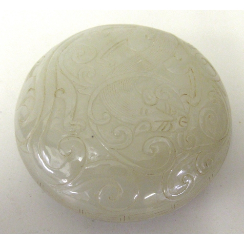 127 - Small 20th Century carved pale green jade circular box and cover, decorated in shallow relief, 8.5cm... 