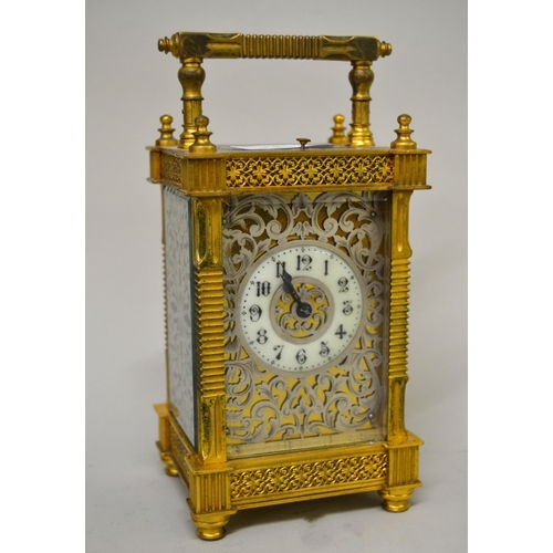 Good quality late 19th / early 20th Century gilt brass cased carriage clock with a silvered fretwork dial and sides, circular enamel chapter ring with Arabic numerals, the ornate gilt brass case enclosing a two train movement with hour repeat function, 19cm high including the loop handle, with key
