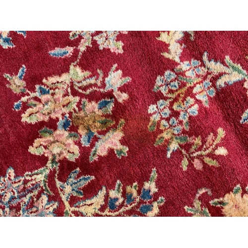 14 - Kirman carpet with a central lobed medallion and all-over stylised floral design, on a rose pink gro... 