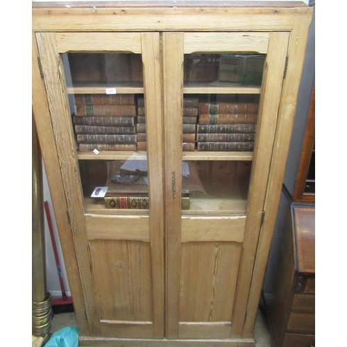 1489 - 19th Century pitch pine cupboard with two glazed and panelled doors enclosing shelves above a plinth... 