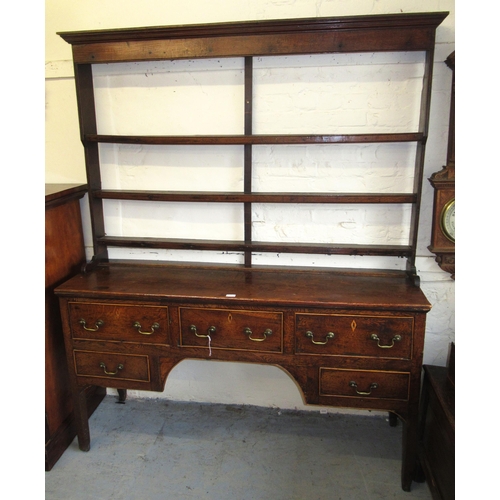 1567C - George III oak and elm dresser, the plank top above an arrangement of five drawers surrounding a cen... 