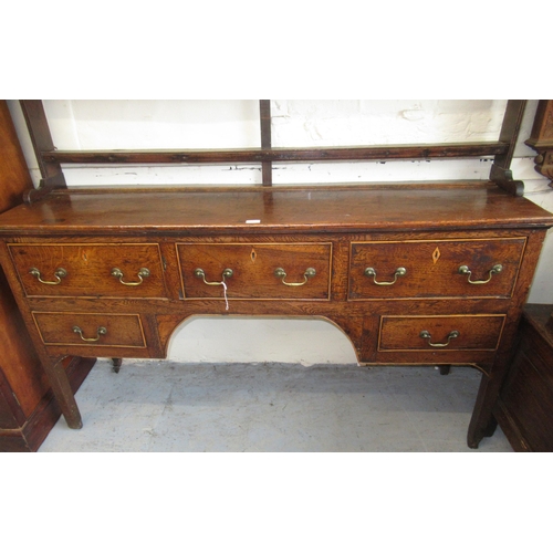 1567C - George III oak and elm dresser, the plank top above an arrangement of five drawers surrounding a cen... 