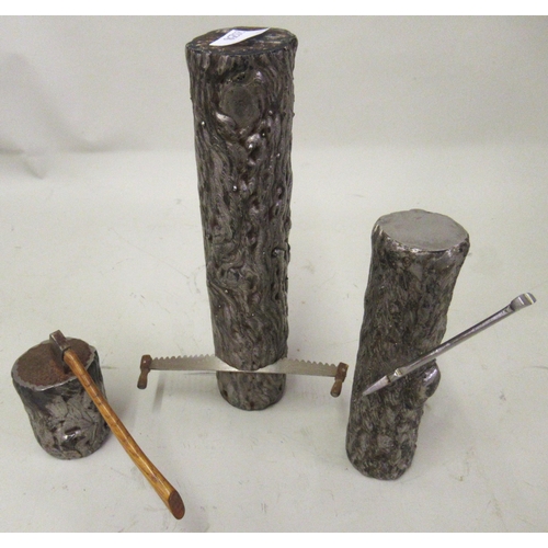 231 - Three small modern steel sculptures of logs with axes and a saw