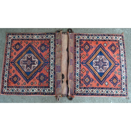 34 - Pair of Kurdish tent bags, each with a single central medallion on a brick red ground with borders a... 