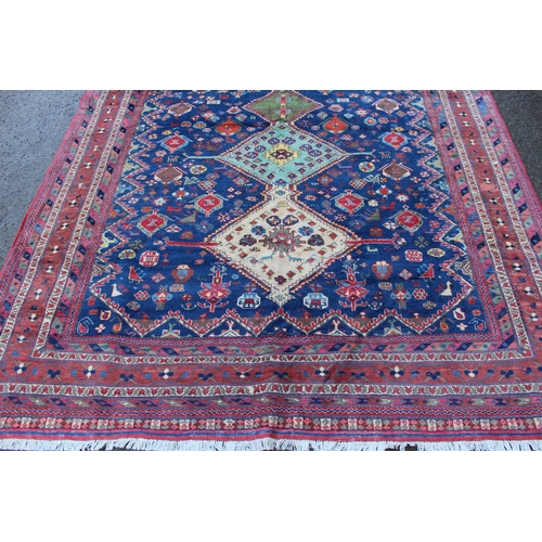 13 - Modern Qashqai carpet with a pole medallion and all-over stylised floral design on a blue ground wit... 