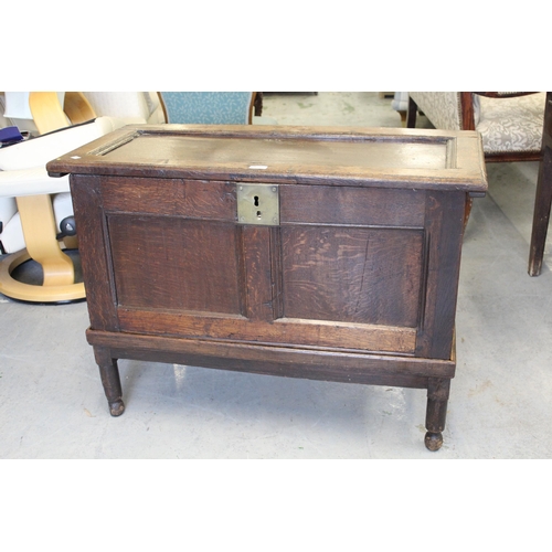 1638 - Small oak coffer on stand, the hinged single panel top above a two panel front on a replacement base... 