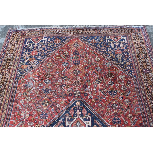 18 - Qashqai rug with a medallion and all-over stylised floral design on a red ground with borders, 243 x... 