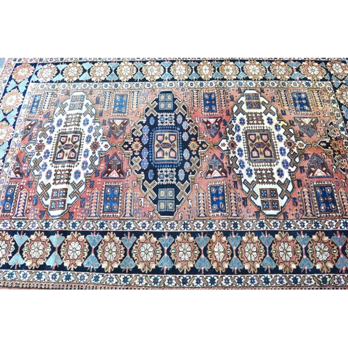 3 - Kazak rug with a triple medallion design on a rose ground with rosette border, 218 x 146cm