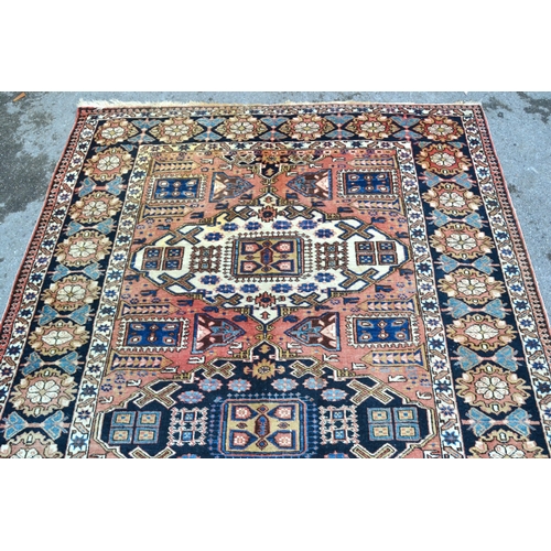 3 - Kazak rug with a triple medallion design on a rose ground with rosette border, 218 x 146cm