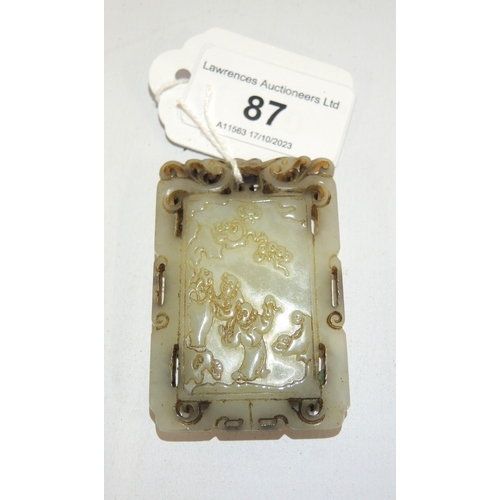 87 - Rectangular carved pale jade pendant, decorated with a group of figures to one side and panels of sc... 