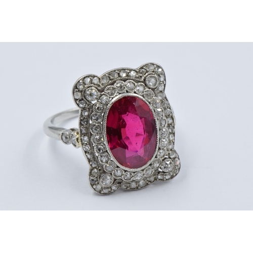Early 20th Century oval treated or synthetic ruby and diamond dress ring, the ruby approximately 10mm x 7mm, size K, 4.5g