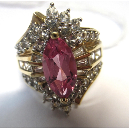 1063 - 10ct Yellow gold dress ring set pink centre stone flanked by white stones, size N, 7.8g