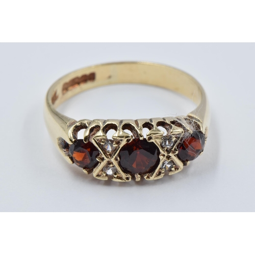 1070 - 9ct Yellow gold three stone garnet ring, size K, 2.4g