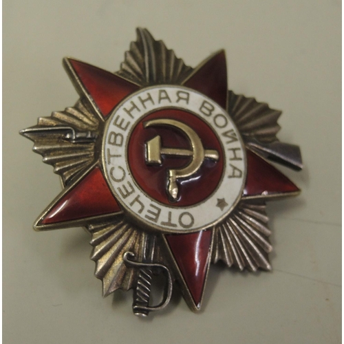 194 - Soviet silver and enamel Order of The Patriotic War medal with screw back and two associated booklet... 