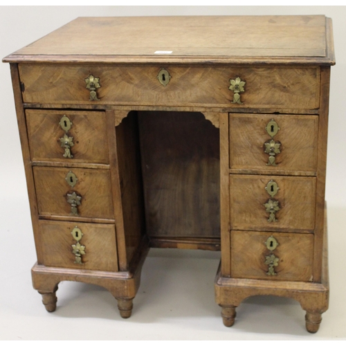 2040 - Small 18th Century oak and walnut kneehole desk, the moulded top above an arrangement of seven drawe... 