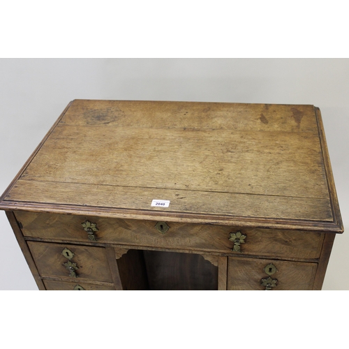 2040 - Small 18th Century oak and walnut kneehole desk, the moulded top above an arrangement of seven drawe... 