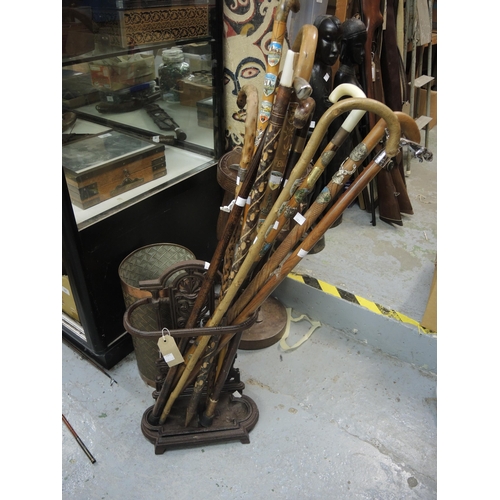 391 - Small cast iron stick stand and a quantity of walking sticks