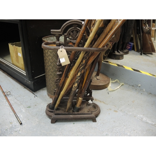 391 - Small cast iron stick stand and a quantity of walking sticks