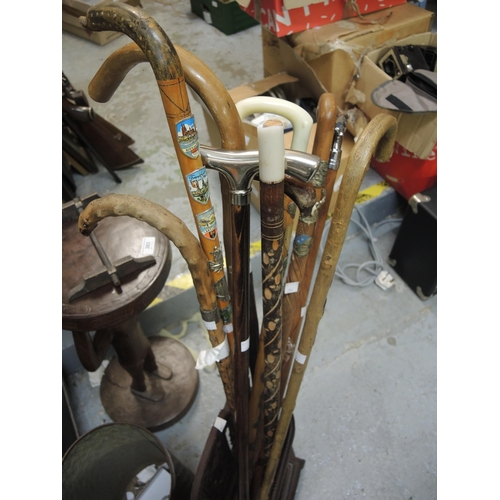 391 - Small cast iron stick stand and a quantity of walking sticks