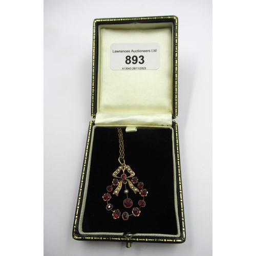 893 - Edwardian gold pendant of bow form set rubies and seed pearls suspended from a gold plated chain