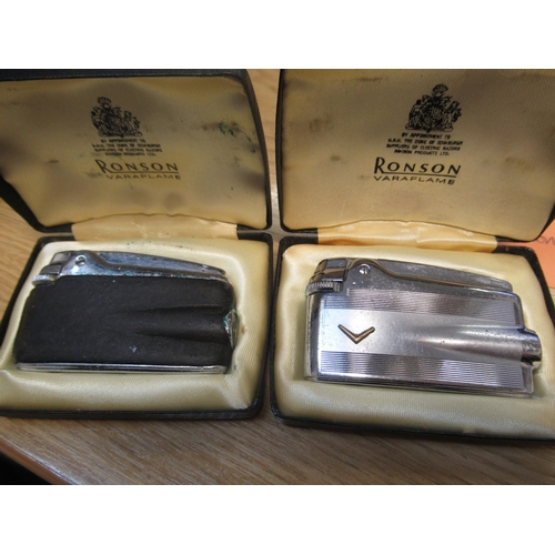 974 - Gold plated Dunhill lighter (lacking box), together with two cased Ronson cigarette lighters