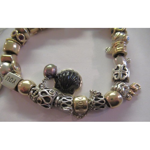 890 - Pandora charm bracelet with multiple 9ct gold, 15ct gold and silver charms, gross weight 87.8g