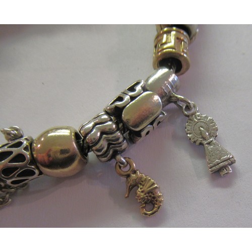 890 - Pandora charm bracelet with multiple 9ct gold, 15ct gold and silver charms, gross weight 87.8g