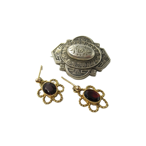 604 - Pair of 9ct gold and garnet earrings, together with a Victorian white metal brooch