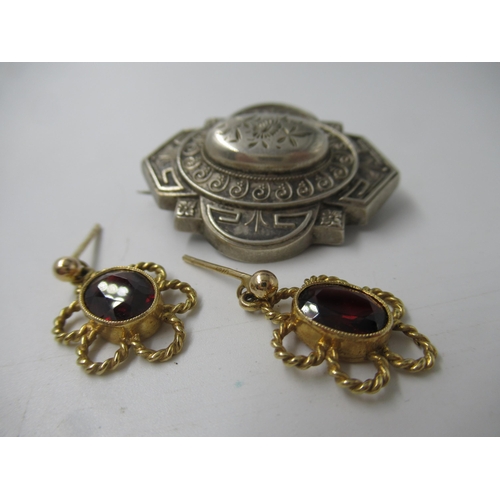 604 - Pair of 9ct gold and garnet earrings, together with a Victorian white metal brooch