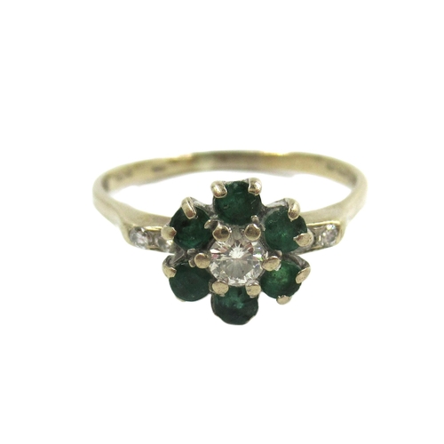 606 - 18ct Gold emerald and diamond flowerhead ring with diamond set shoulders, 2.7g