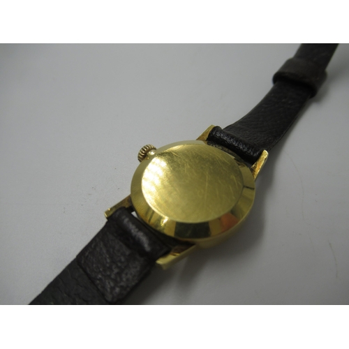 685 - Ladies 9ct gold cased Omega wristwatch with gilt dial and baton numerals, on a brown leather strap