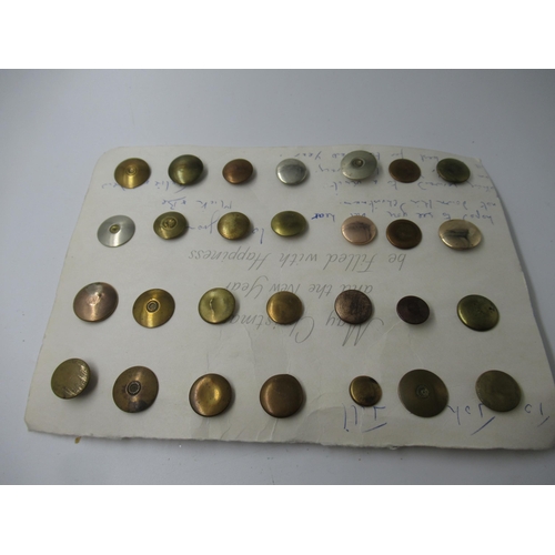 569 - Card containing a collection of twenty eight bachelor buttons in brass and gold plate